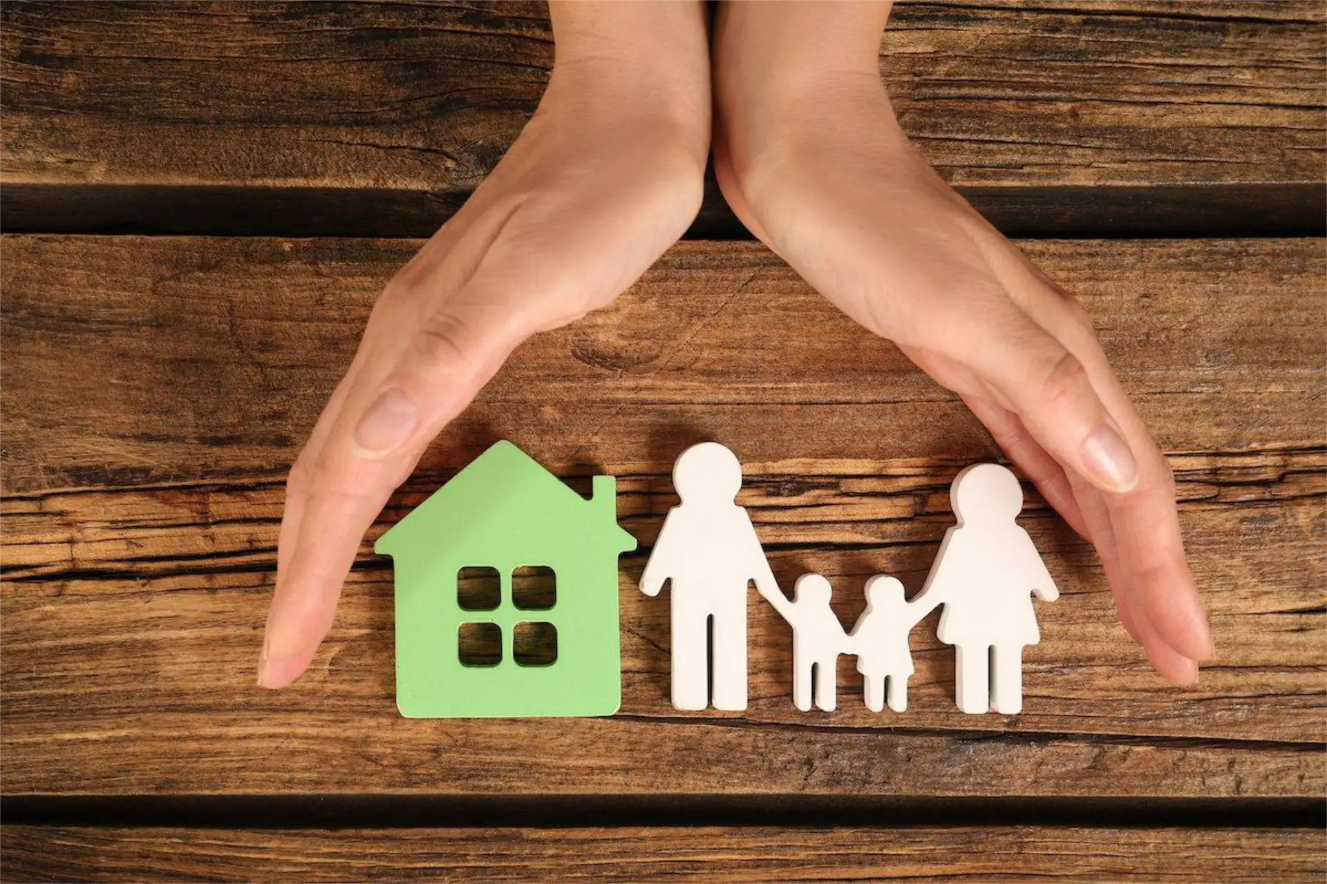 Life insurance - concept hands covering family and house